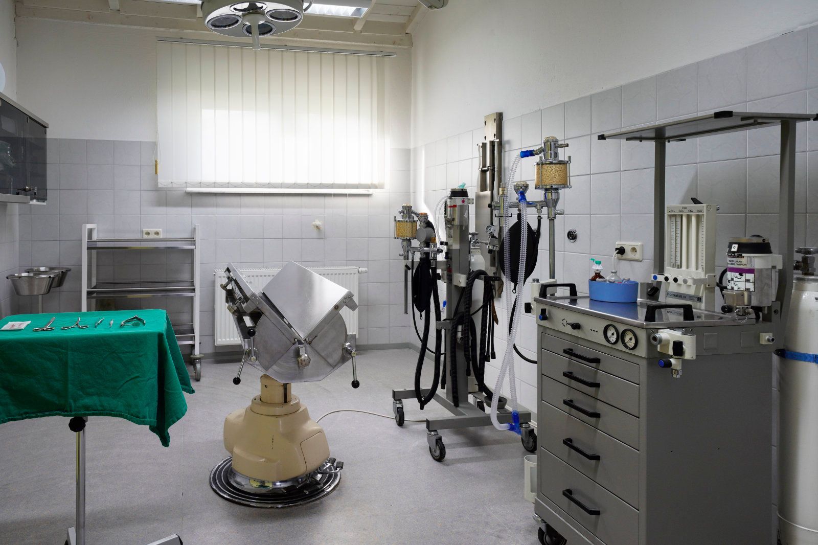 Ein leerer Operationssaal mit einem Tisch und Stühlen.