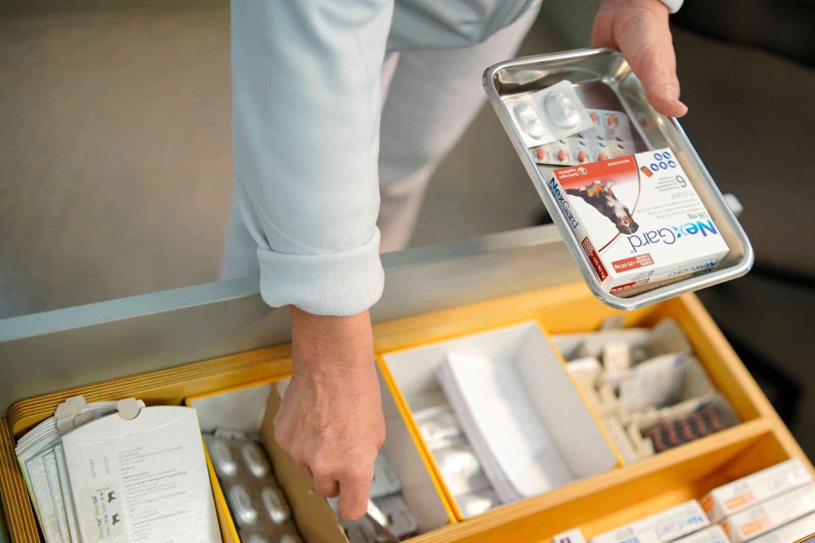 Eine Person nimmt ein Tablett mit Pillen aus einer Schublade.