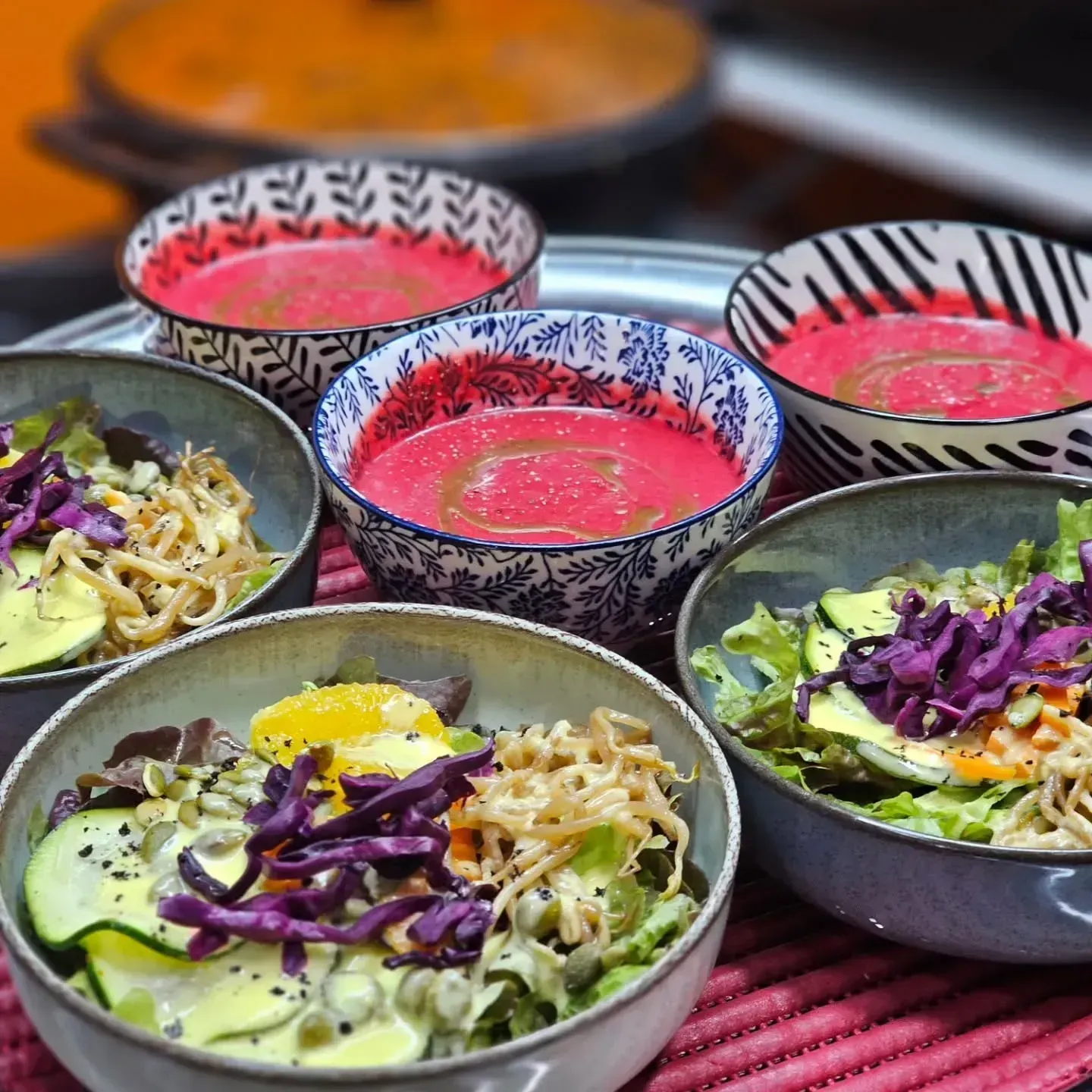 Cuencos de ensalada colorida o platos de cereales con aderezo rosa sobre una mesa.