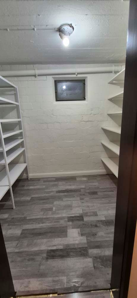 Ein Schrank mit Regalen und einem Fenster in einem Keller.