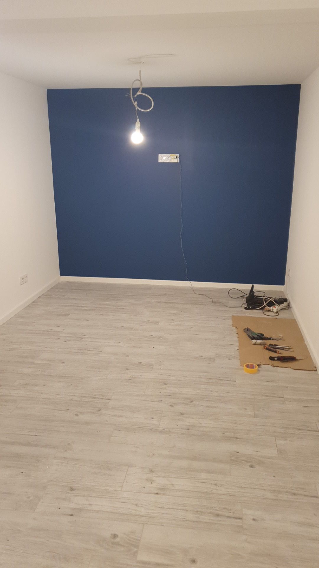 ein Raum mit einer blauen Wand und einem Licht an der Decke.