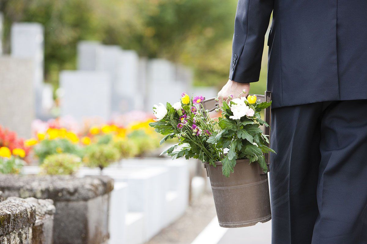 Homme qui amène des fleurs sur une tombe.