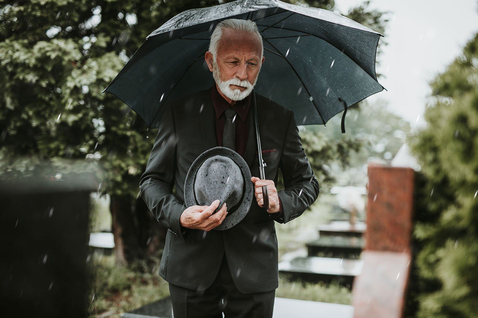 Homme qui fait son deuil dans un cimetière.