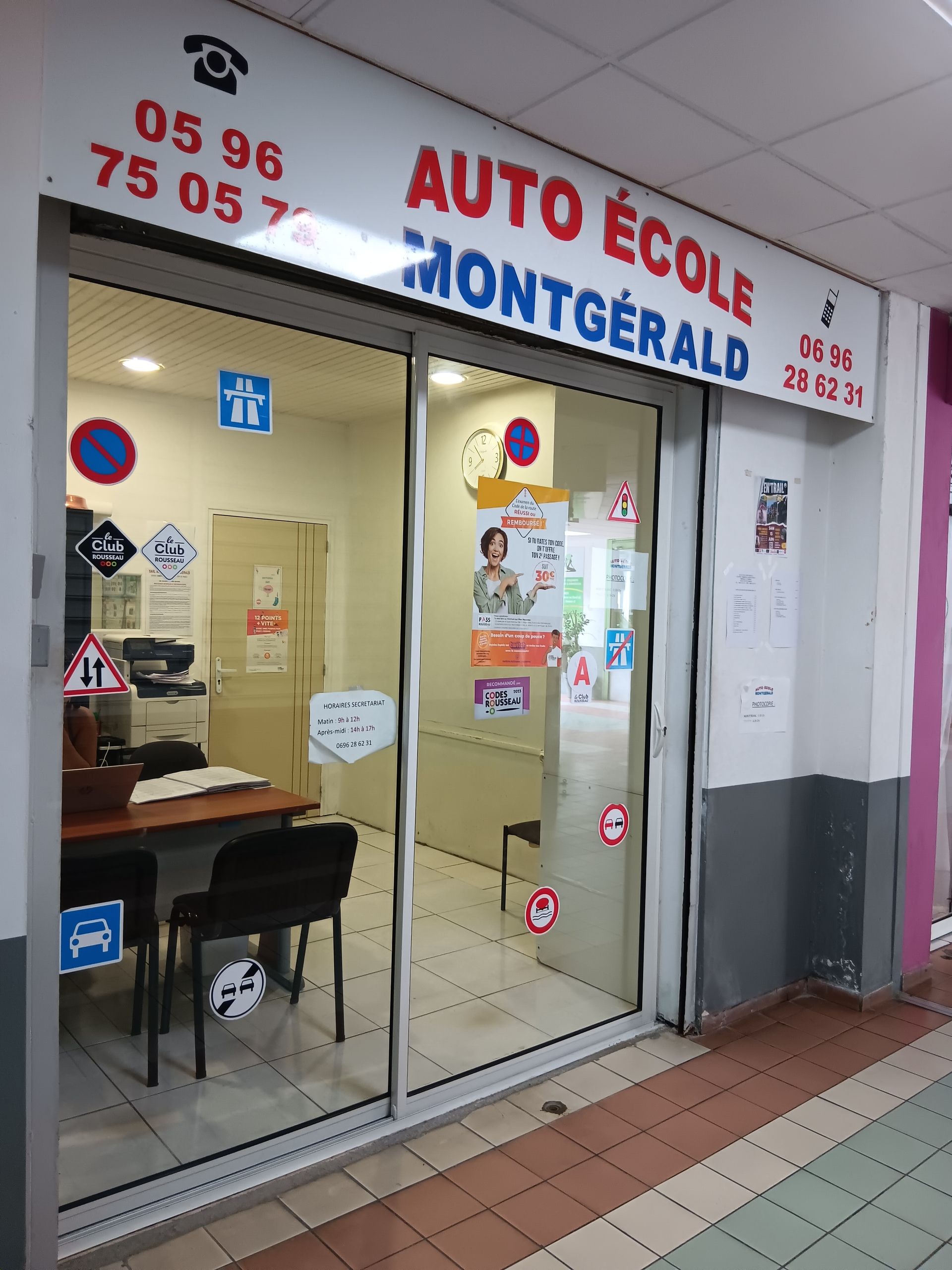 Façade de l'auto-école Montgérald avec portes vitrées, laissant apparaître l'espace d'accueil et l'enseigne.