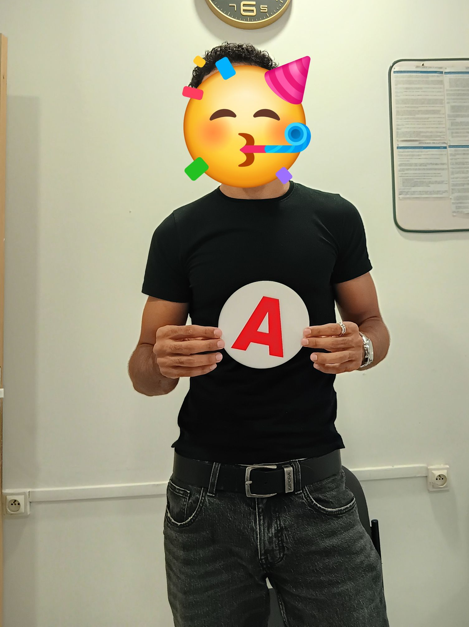 La main d'une personne tient le volant noir d'une voiture. Le soleil brille à travers le pare-brise.