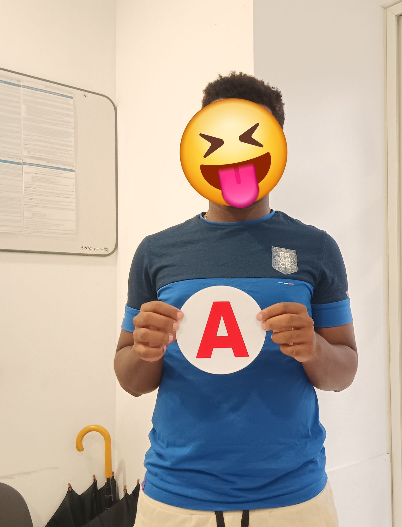 Une petite voiture rouge à côté d'un permis de conduire français rose, posé sur une surface en bois.