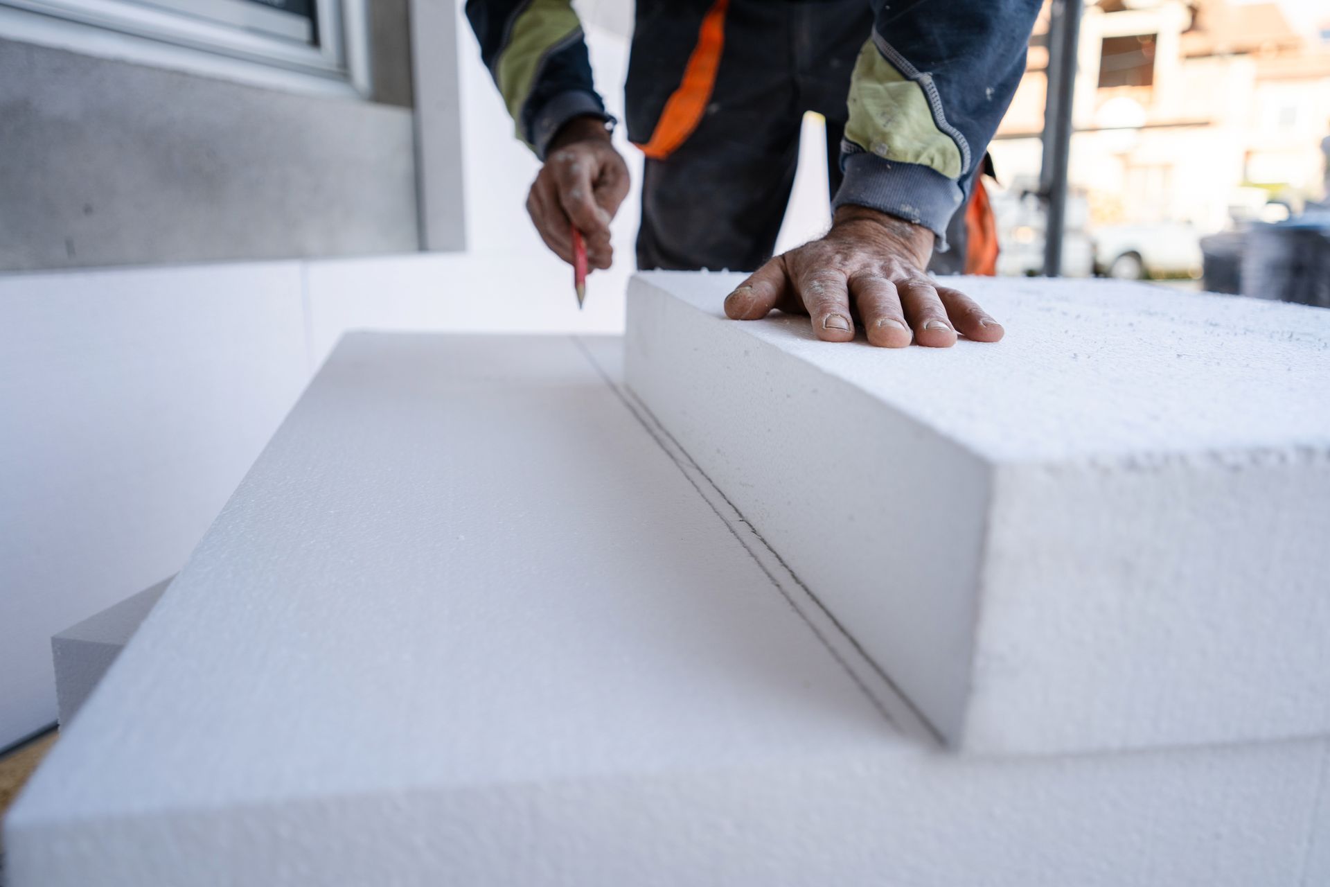 Artisan traçant des lignes au crayon à papier sur bloc de polystyrène