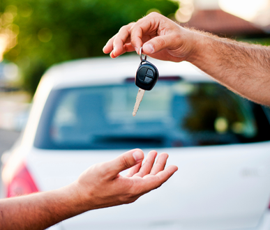Un homme donne une clé de voiture à un autre homme