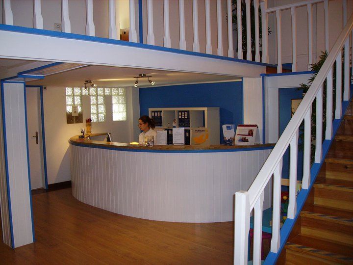 Uma mulher está atrás de um balcão em uma sala com escadas