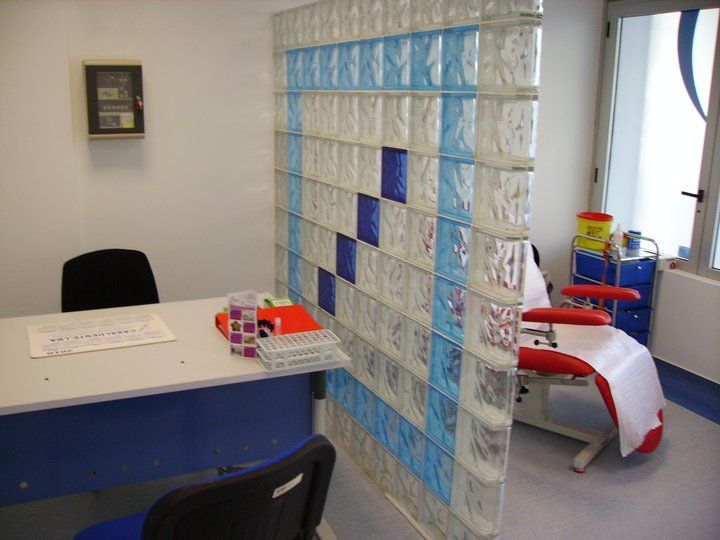 Uma sala com uma parede de blocos de vidro e uma cadeira