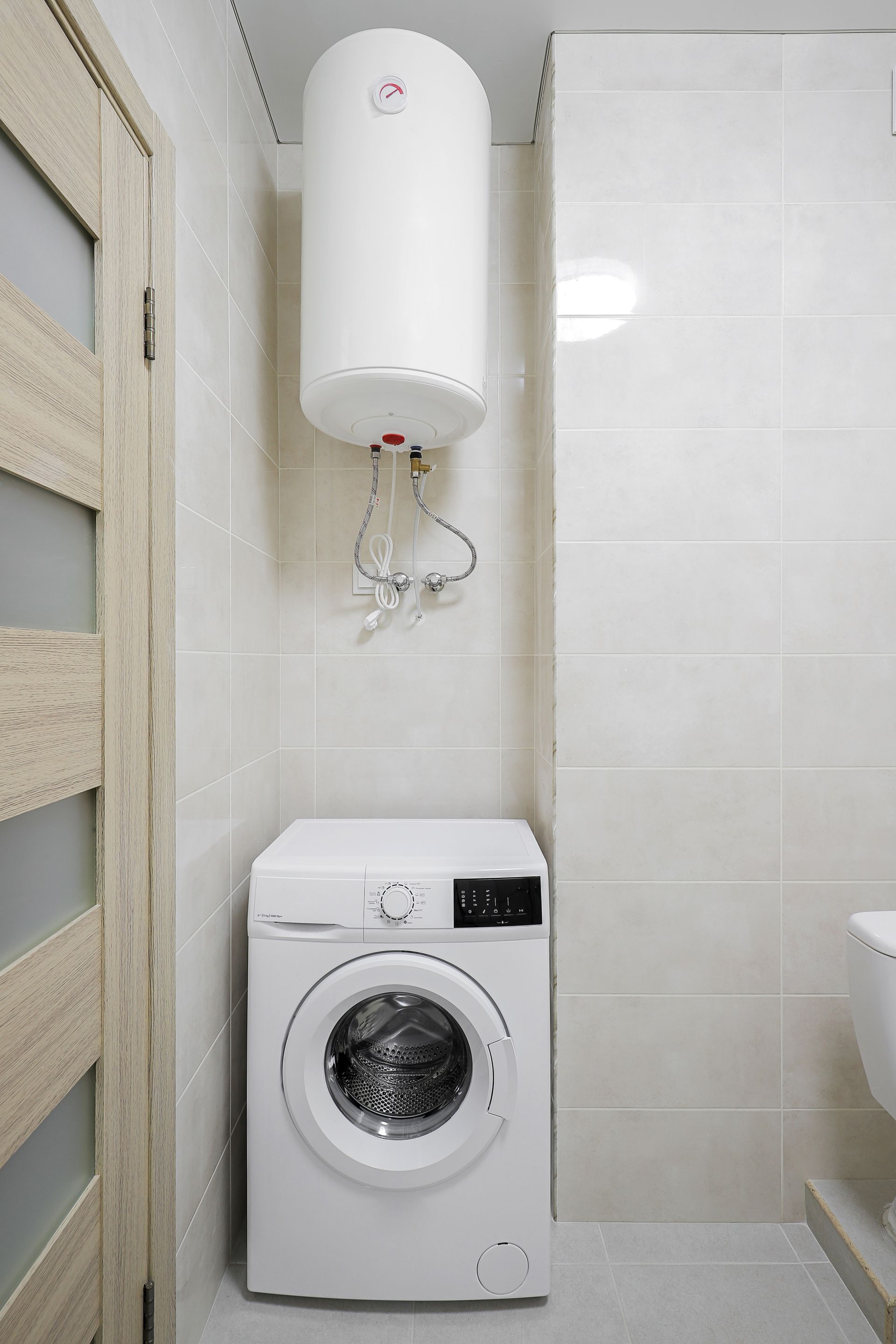 Chauffe-eau installé au dessus d'une machine à laver