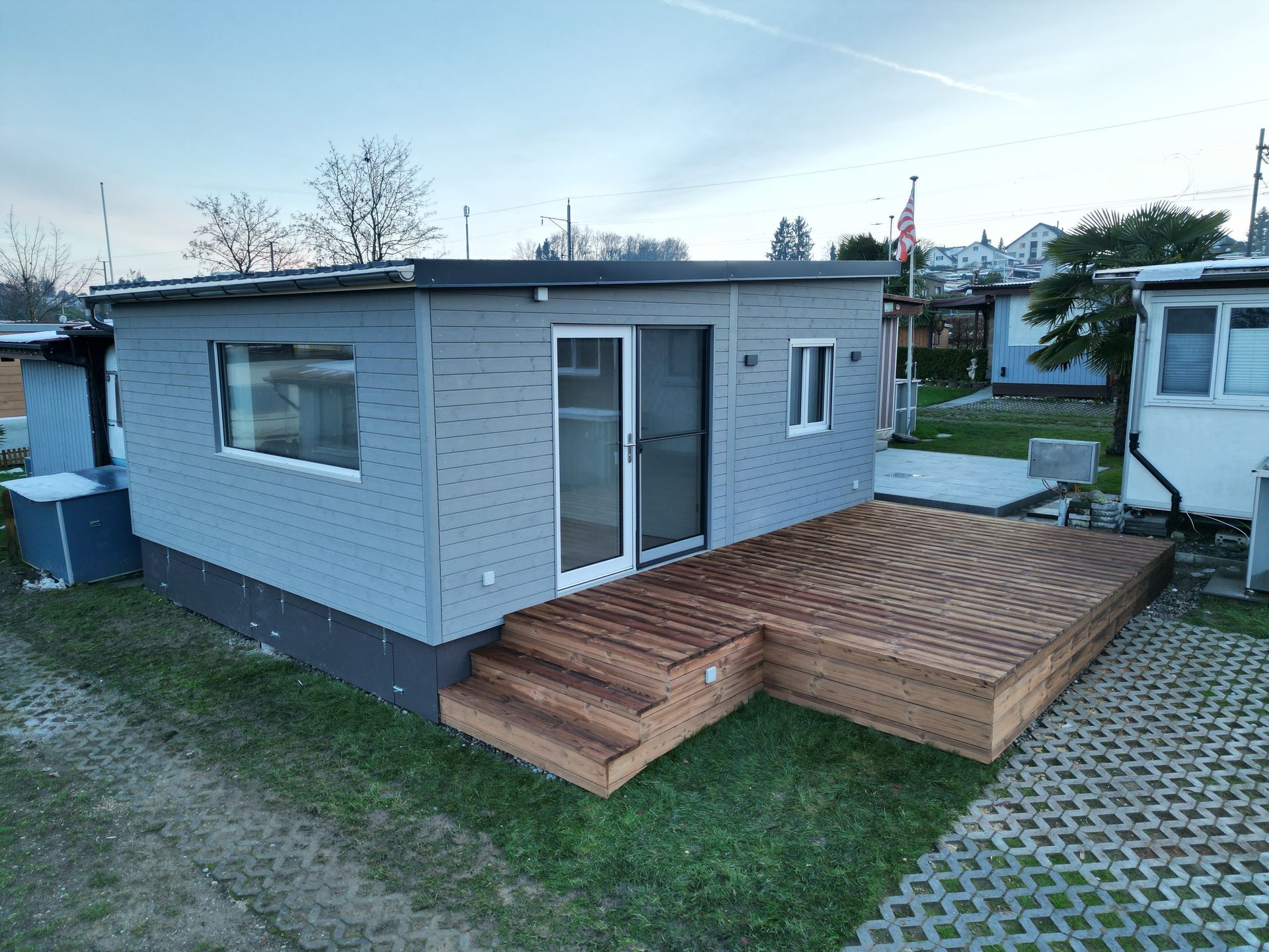 Ein kleines Haus mit einer Holzterrasse davor.