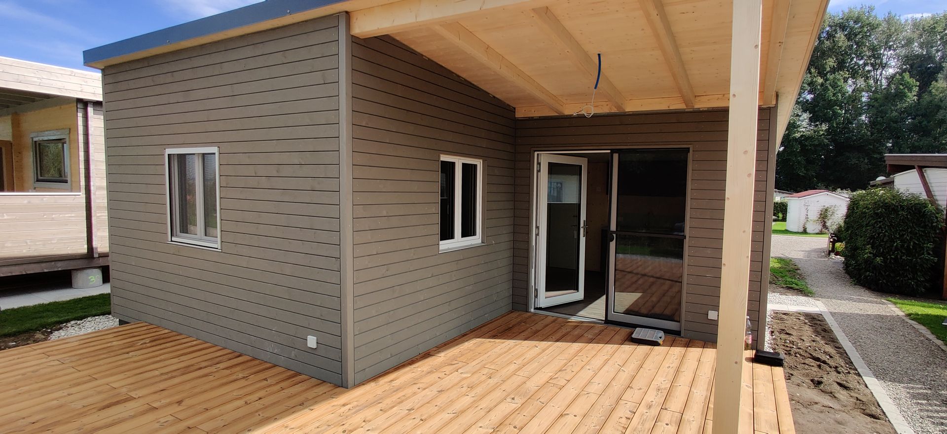 Ein kleines Haus mit einer Holzterrasse davor.