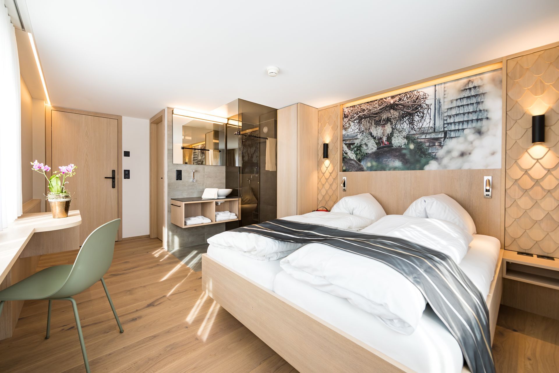 Ein Hotelzimmer mit Bett, Stuhl, Schreibtisch und Badezimmer.