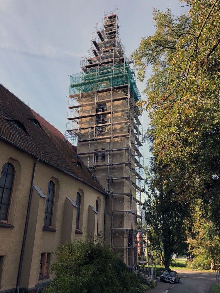 Ein Kirchturm mit Gerüst herum.  Foto von der VRBA Gerüstbau & Containerservice GmbH.