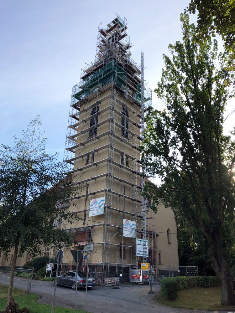 Ein Kirchturm mit Gerüst herum.  Foto von der VRBA Gerüstbau & Containerservice GmbH.