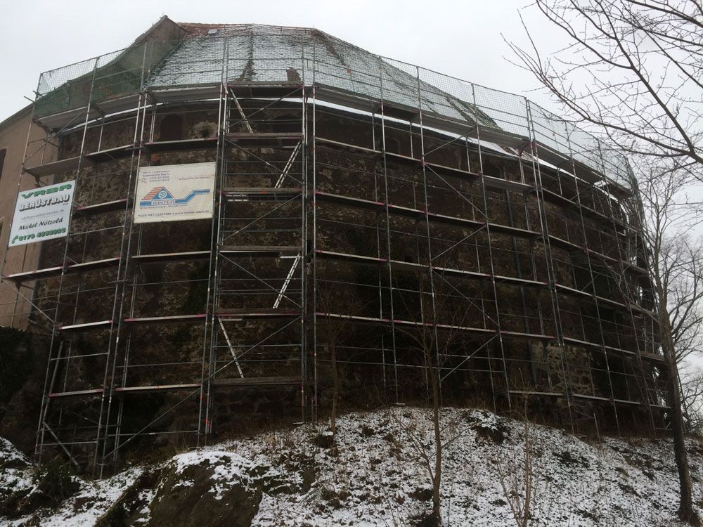 Ein großes Gebäude ist mit Gerüsten und Schnee bedeckt. Foto von der VRBA Gerüstbau & Containerservice GmbH.