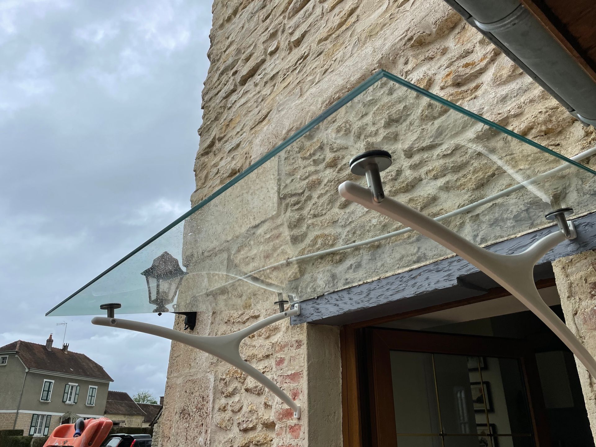 Marquise en verre sur un mur en pierre