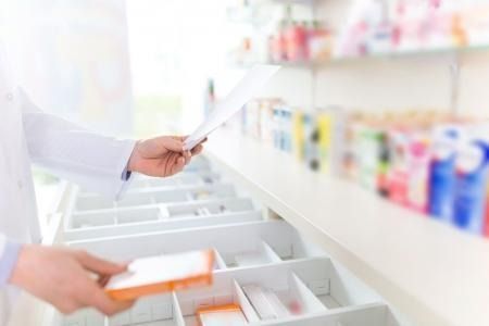 Un farmacéutico está mirando una receta en una farmacia.