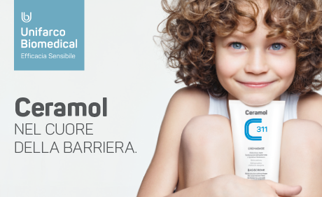 Bambino sorridente tiene in mano un tubetto di crema Ceramol; pubblicità per prodotti per la cura della barriera cutanea.