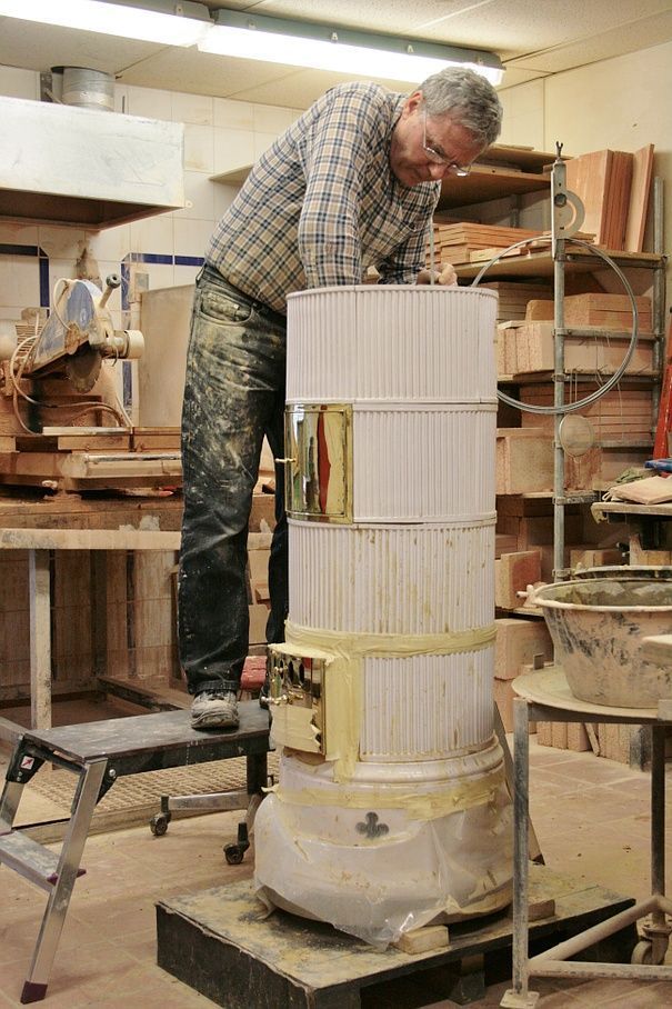 Construction et pose de pierres réfractaires sur un poêle en faïence rond Biedermeier