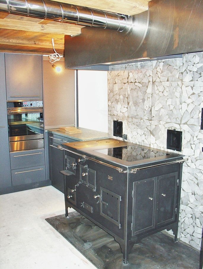 Cucina d’epoca con focolare a legna e piano in vetroceramica