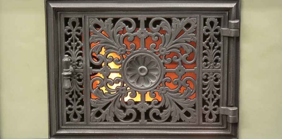 View of the fire in stove behind door with decorative cutwork (this can also be fully opened)