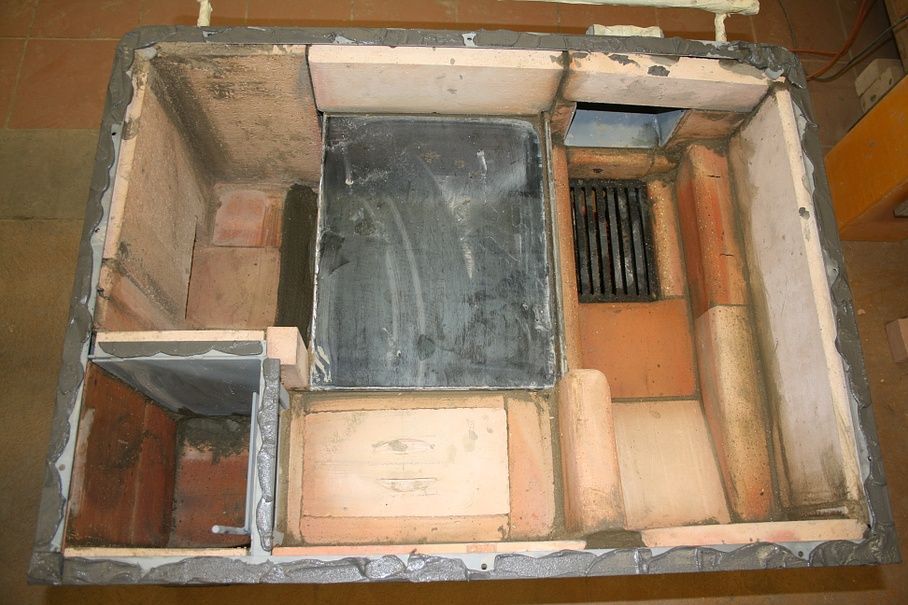 Pose de pierres réfractaires sur un fourneau à bois