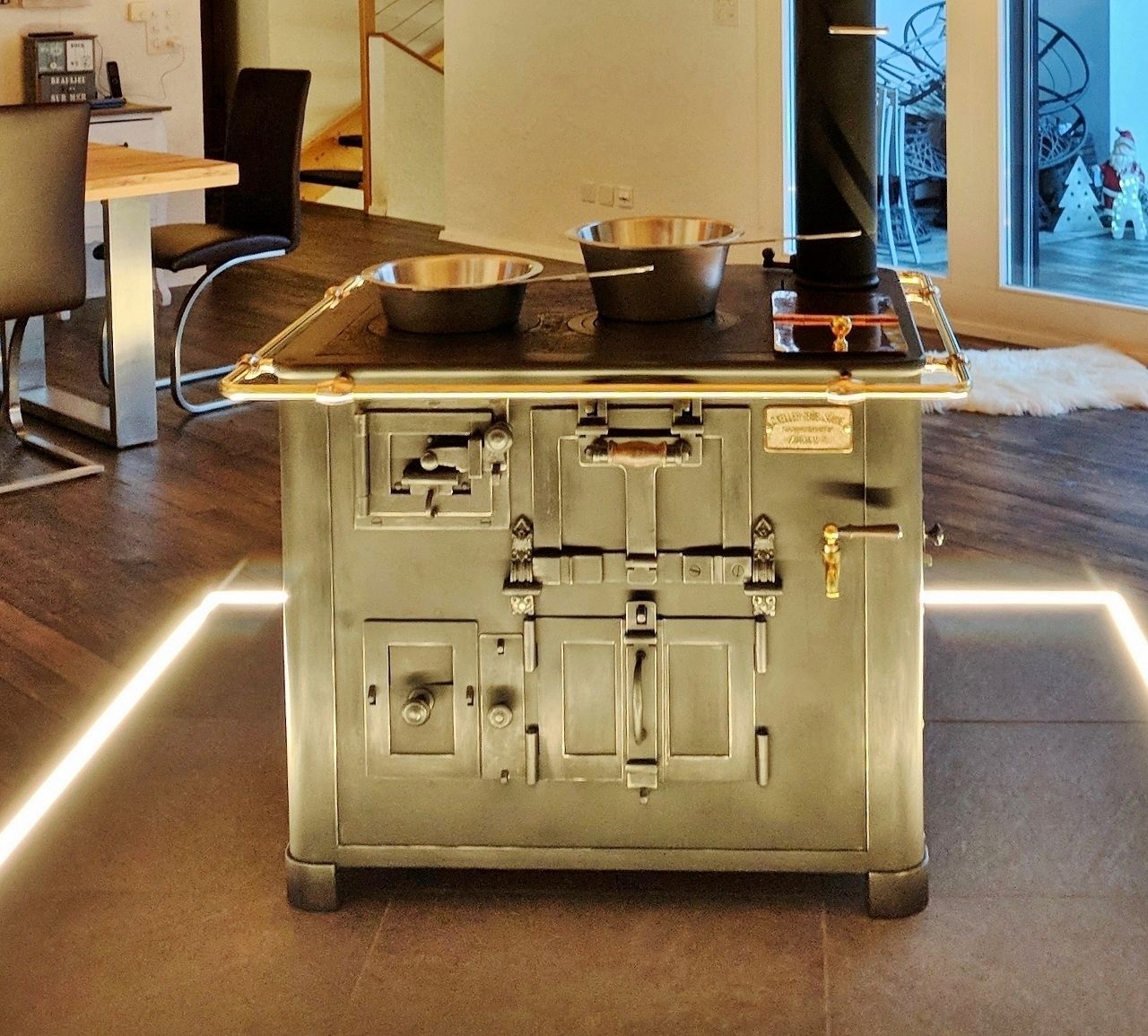 Cucina a legna originale d’epoca al centro della stanza con illuminazione a pavimento