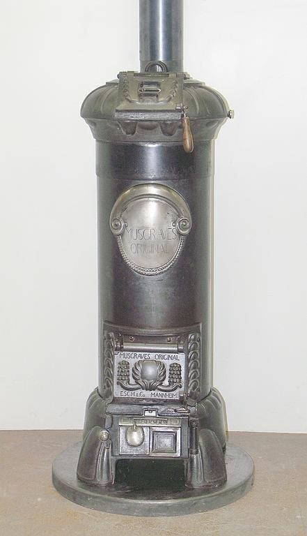 Poêle en fonte n° 1341 – Perler Ofen/ Musgrave, original d’Irlande, construit sous licence par la société Esch & Cie. Mannheim. Poêle cylindrique avec de très beaux éléments décoratifs. Facile à charger par le haut.