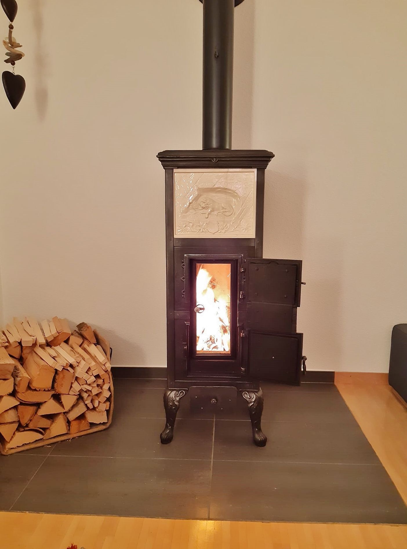 Gestellkachelofen mit grosser Feuersicht und Frontkachel, welches das Löwendenkmal zeigt