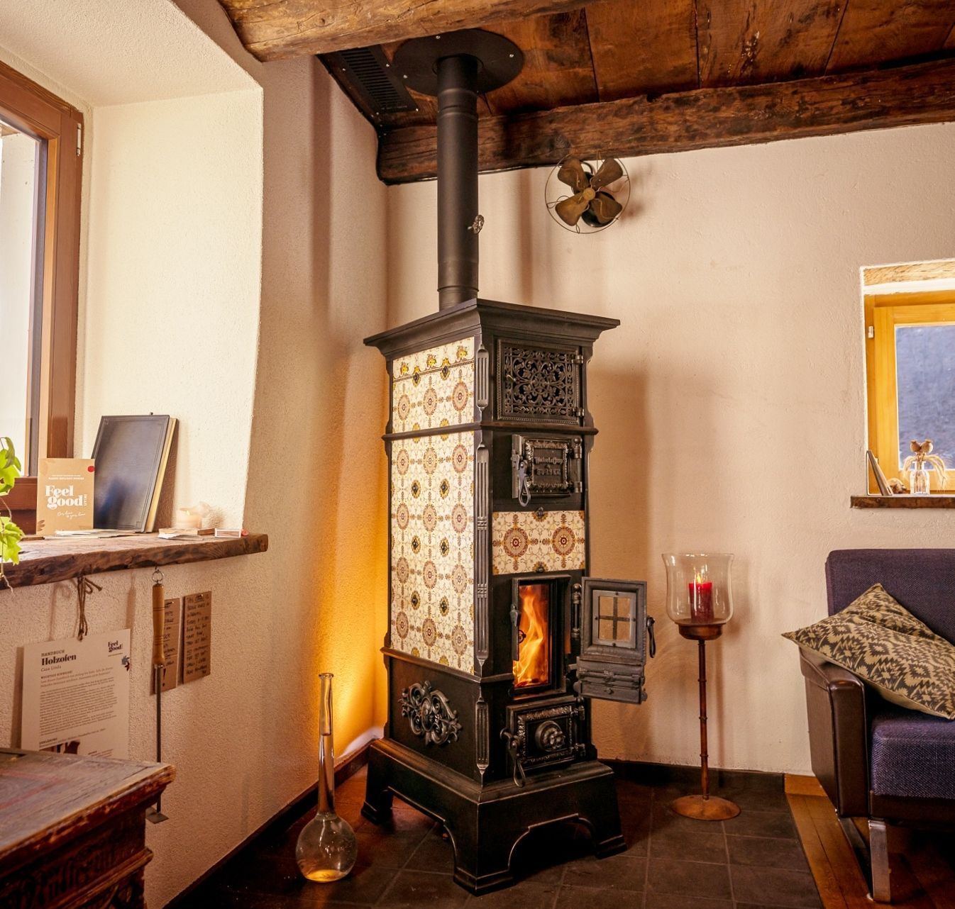 Gestellkachelofen von der ehem. Ofenfarbik Weltert & Cie. in Sursee, mit mehrfarbigen Keramikplatten und Glastüre für Sicht auf die Flammen