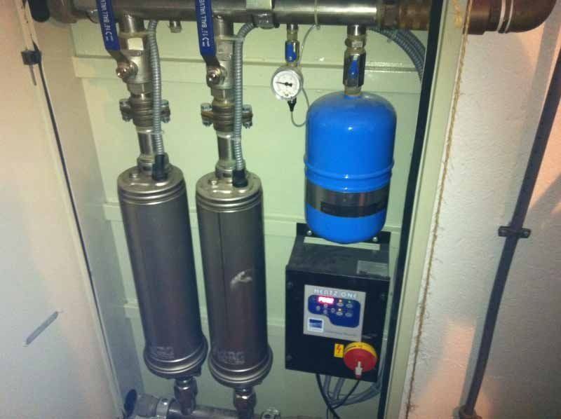 Un tanque azul cuelga de una pared junto a un panel de control.