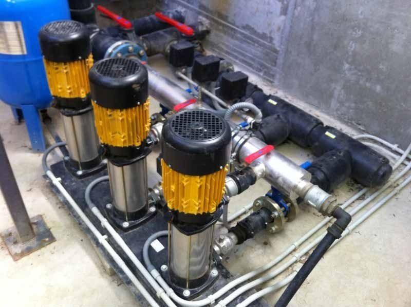 Un montón de bombas y tuberías están alineadas en una habitación.