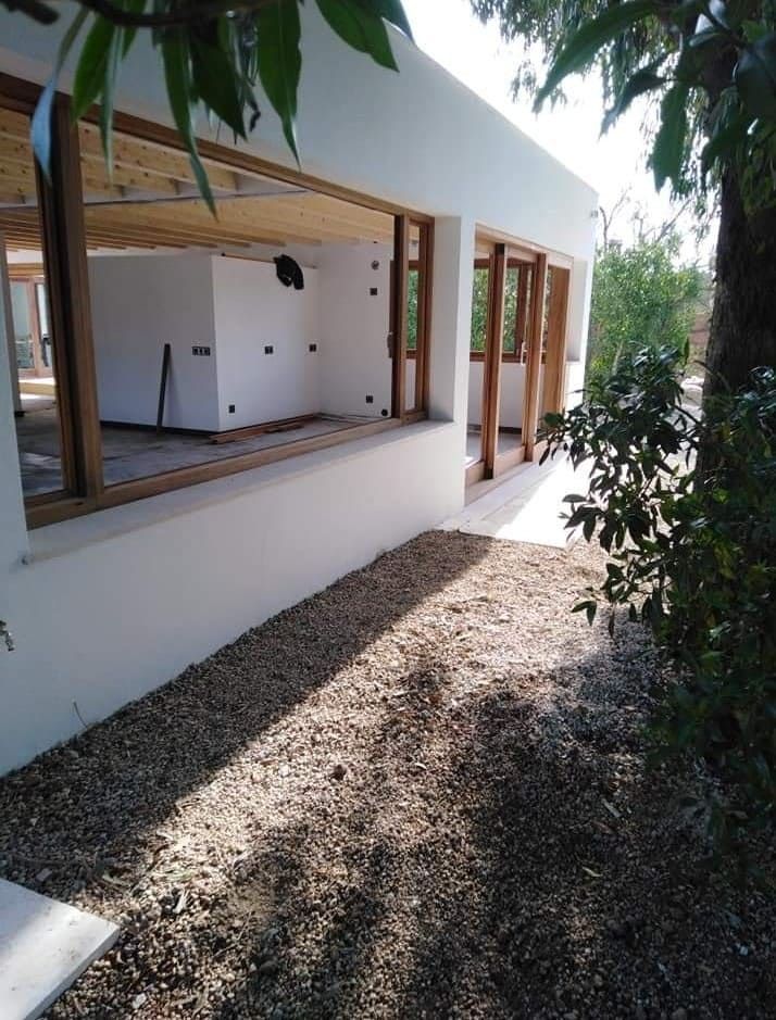 Un edificio blanco con muchas ventanas y grava delante.