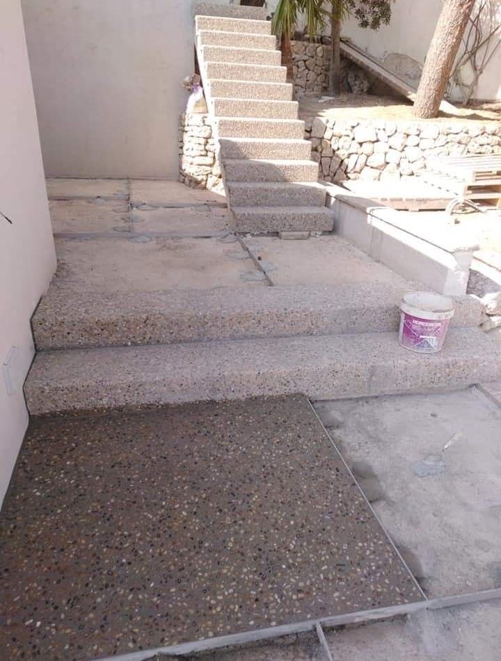 Un cubo de hormigón está en el suelo al lado de unas escaleras.