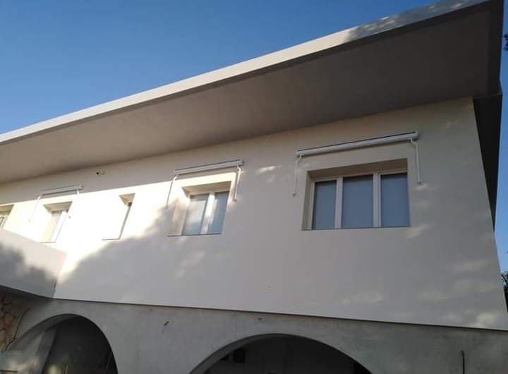 Un edificio blanco con arcos y un cielo azul al fondo.