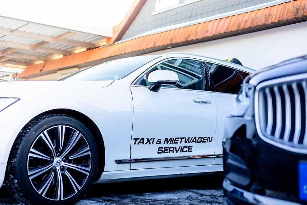 ein weißes Auto steht neben einem schwarzen Auto .