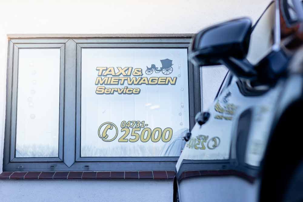 ein weißes Auto steht vor einem Fenster mit einem Schild darauf .