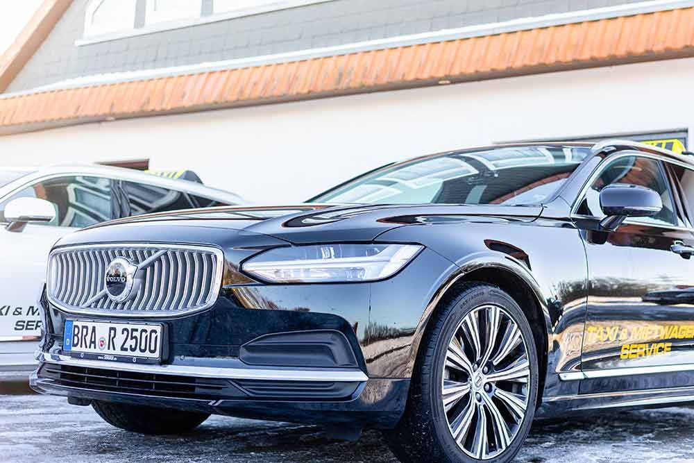 ein schwarzes volvo-Auto steht vor einem Gebäude .