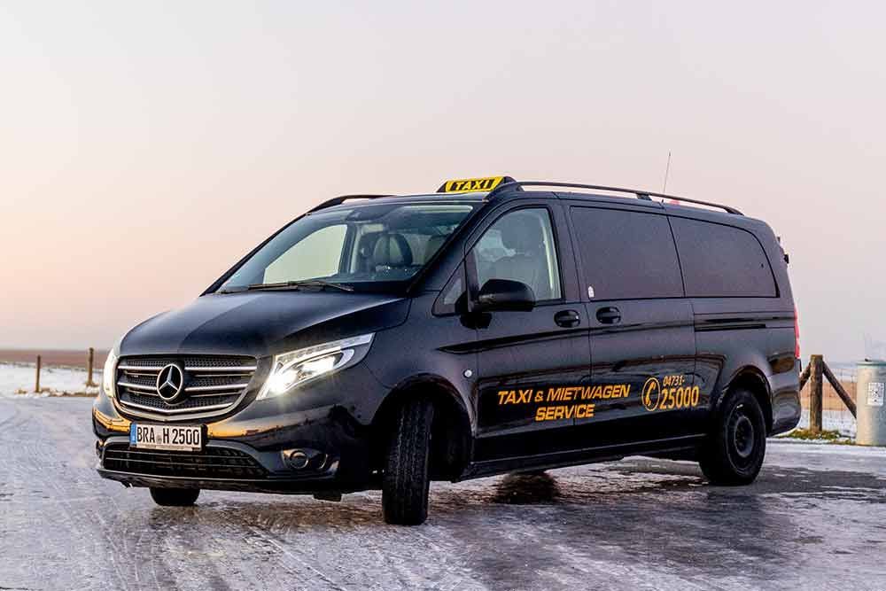 ein schwarzer mercedes-benz minivan steht auf einer schneebedeckten straße .