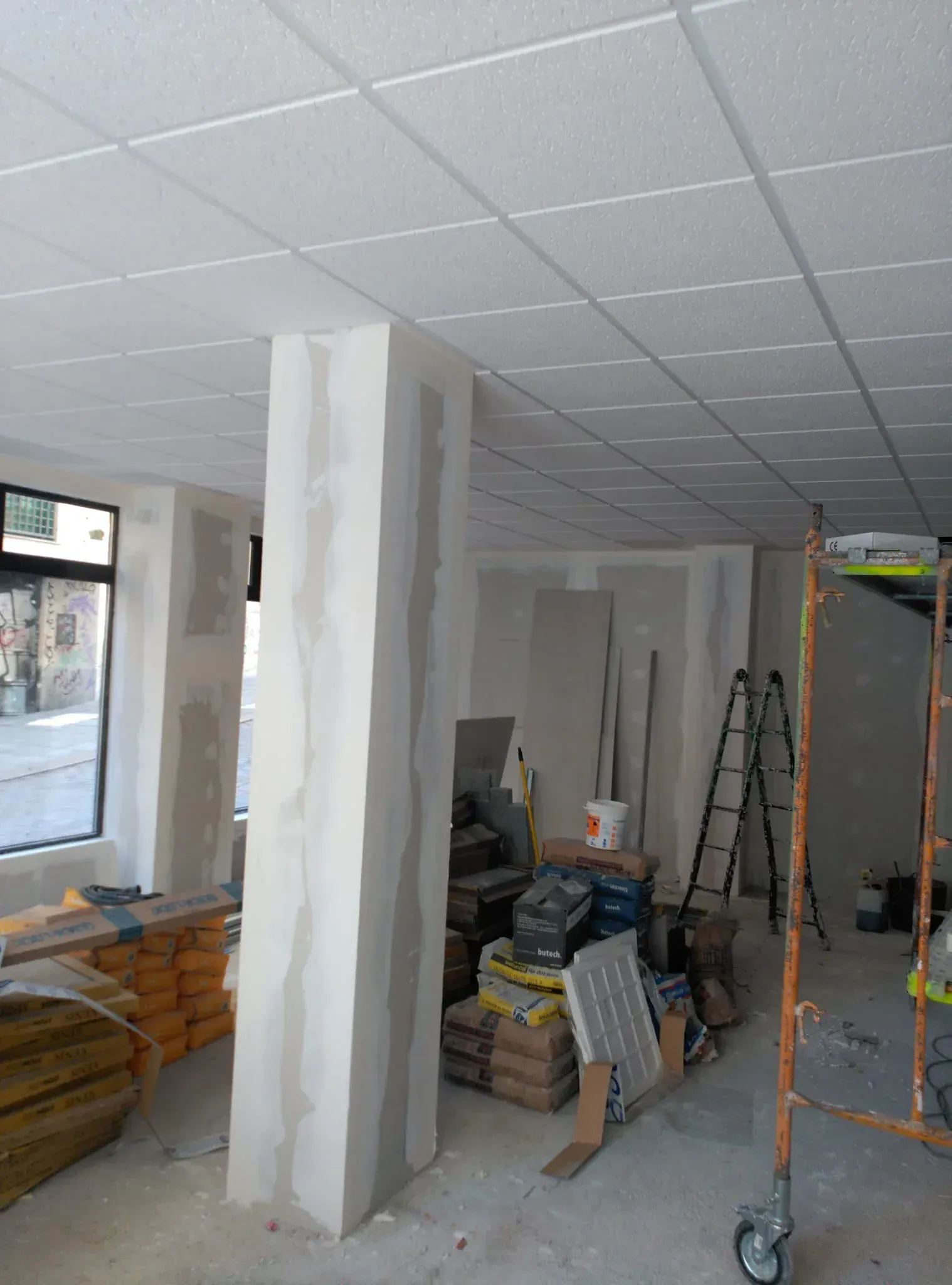 Interior de una obra en construcción con un pilar con acabado de yeso