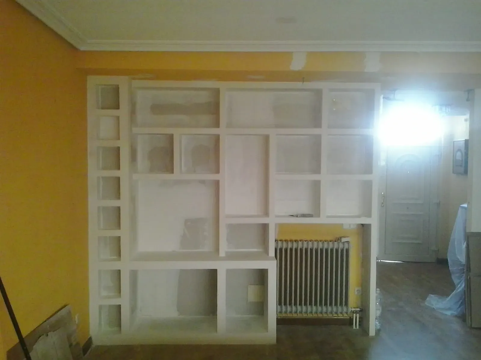 Estantería empotrada blanca hecha a medida e integrada en una pared