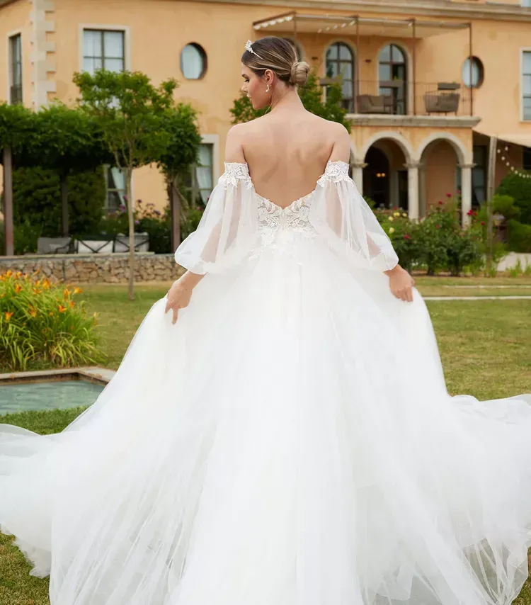 Eine Frau in einem Brautkleid steht vor einem Haus