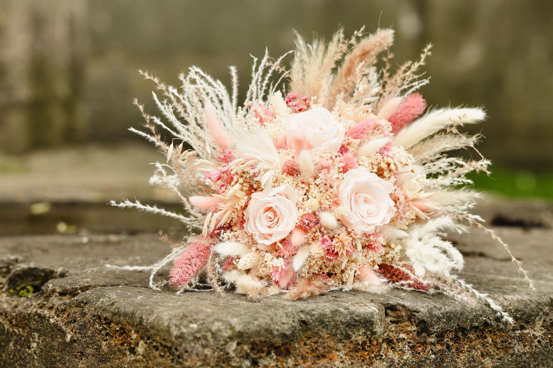 Auf einem Felsen liegt ein Strauß getrockneter Blumen.