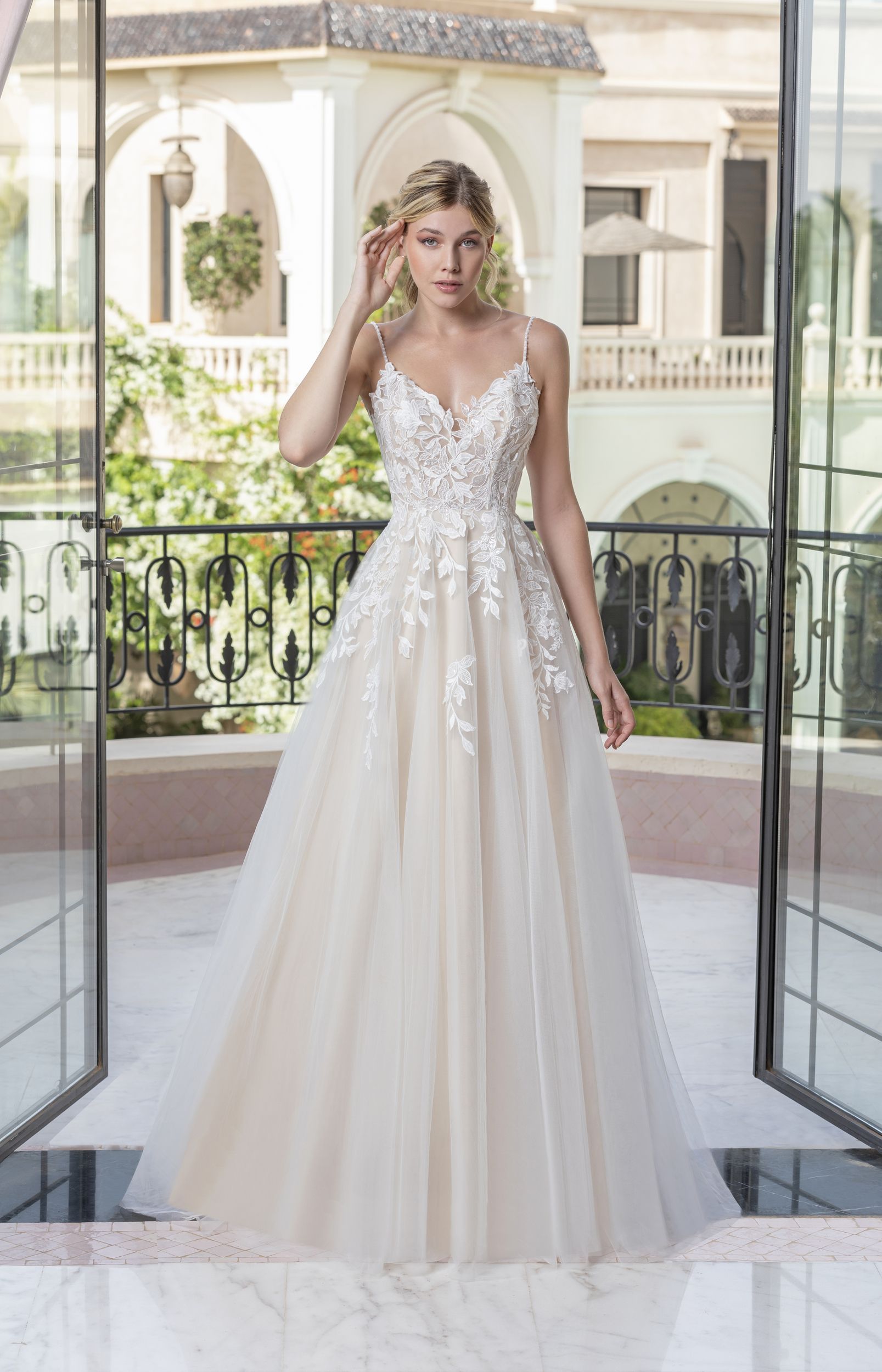 Eine Frau in einem Brautkleid steht vor einem Gebäude.