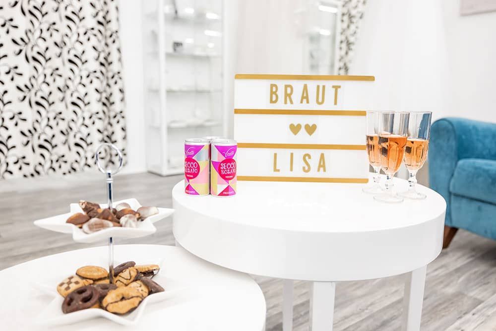 Ein Tisch mit einem Teller Kekse und einem Schild mit der Aufschrift „Braut Lisa“.