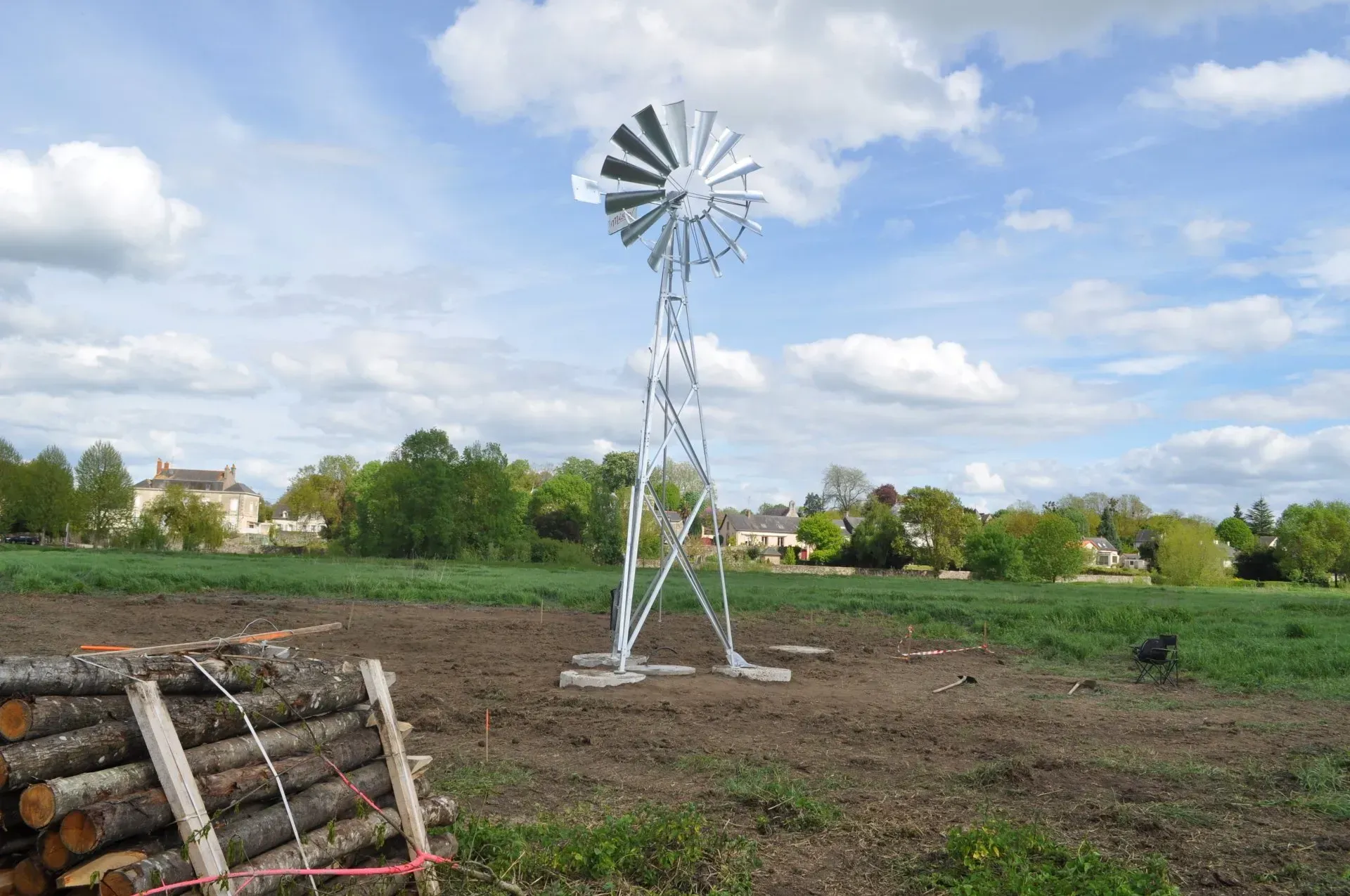 Éolienne dans un champ avec une pile de bois