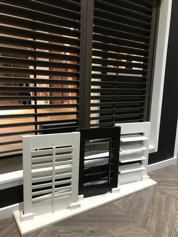 Eine Ausstellung verschiedener Arten von Fensterläden vor einem Fenster.