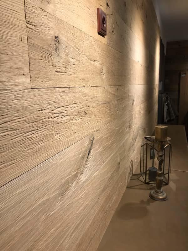 Eine Holzwand mit Kerzen darauf in einem Flur.